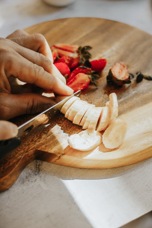 Person Slicing Banana and Strawberries 